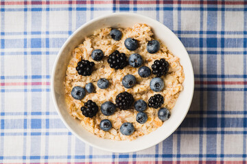 Oatmeal porridge with berries. Selective focus.