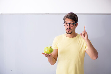 Young male student holding piggybank