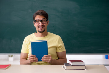 Young male student in front of blackboard