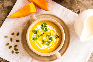 pumpkin soup of ripe orange pumpkin in a plate on a cloth napkin. the concept of healthy eating.