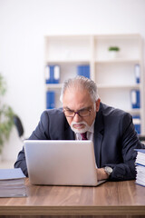 Fototapeta premium Old male employee and too much work in the office