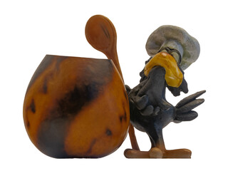 An isolated image of a confectionery in the form of a stylized figure of a crow chef. Nearby is a pot of food. The composition symbolizes the profession of a cook and culinary specialist