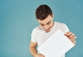 Cheerful man with a sheet of paper in his hands Copy Space emotions blue background