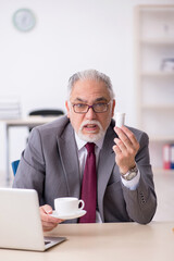 Old businessman feeling bad at workplace