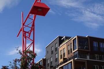 Close up view of red lantern and modern brown buildings with blue sky background in modern district Noblessner. Rowan tree in late summer. Tallinn, Estonia, Europe. Aug. 2021