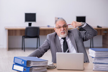 Old male employee unhappy with excessive work in the office