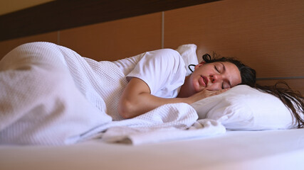 The concept of healthy sleep. Young woman sleeping in white bed.