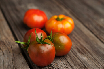 Fresh ripe tomatoeson the old wooden table. Organic food.