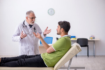 Obraz premium Young man visiting old male doctor