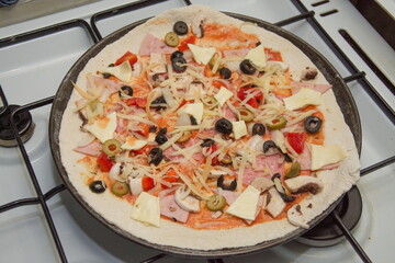 homemade pizza with olives on the stove
