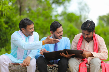 young india bank officer completing paper work with farmers at home.