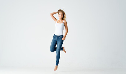 cheap woman in jeans barefoot on the floor fun isolated background