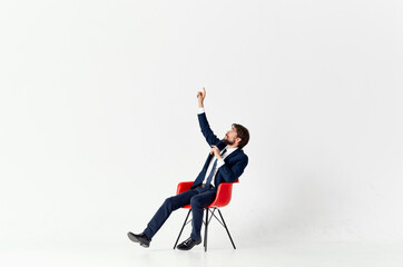 man in suit sitting on red chairs emotions office light background