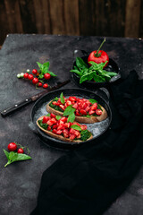 Bruschetta with pesto and tomatoes on a dark background