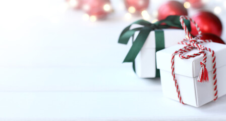 gifts tied with colored bows on a background of red balls and lights of garlands front view. place for christmas greetings