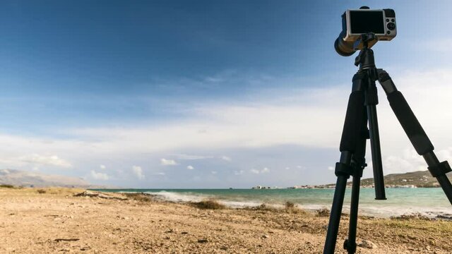 Professional camera taking film video or shooting images pictures of sea coastline in Greece Peloponnese Time lapse