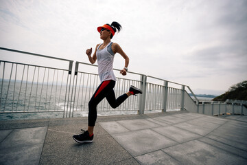 Fitness sports woman runner running on seaside trail