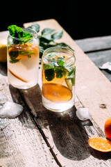 Cold cocktail with tangerine and mint on a wooden table