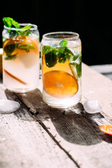 Cold cocktail with tangerine and mint on a wooden table