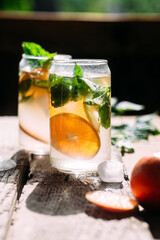 Cold cocktail with tangerine and mint on a wooden table