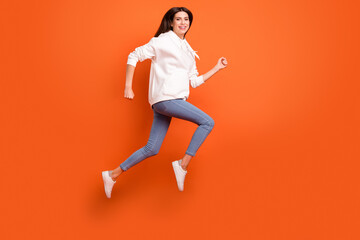 Fototapeta na wymiar Full length body size profile side view of lovely carefree cheerful girl jumping running isolated bright orange color background
