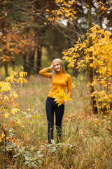 girl walks in the autumn forest. A young woman on a background of yellow and orange leaves