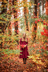 girl in a red dress walks in the autumn forest. Beautiful fairy-tale forest