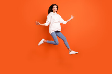 Fototapeta na wymiar Full length body size view of attractive lucky cheerful girl jumping running isolated over bright orange color background