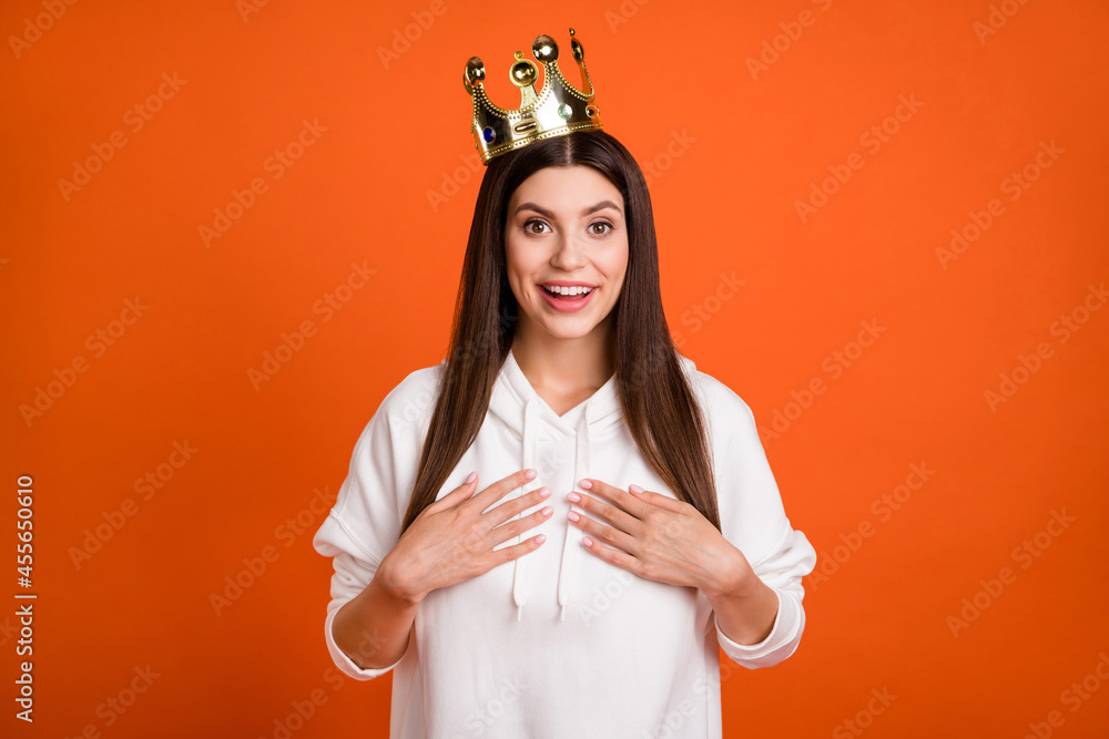 Wall mural Portrait of attractive amazed cheerful girl wearing crown choose me isolated over bright orange color background