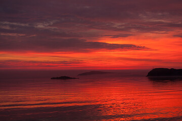 Fototapeta na wymiar fiery red sunset on the sea, red volumetric sky and red water, beautiful red evening landscape