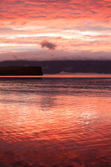 fiery red sunset on the sea, red volumetric sky and red water, beautiful red evening landscape