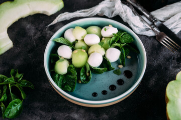 Caprese salad with melon, mozzarella and balsamic sauce. Food styling