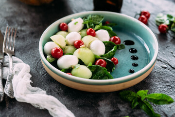 Caprese salad with melon, mozzarella and balsamic sauce. Food styling