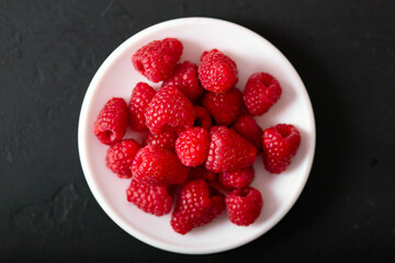 Fresh juicy raspberries on black background.  Summer berries.