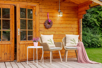 Two chairs in the garden with a pink blanket and heather. Heather as decoration. Chairs to relax and enjoy the time in the garden. Wooden garden shed 