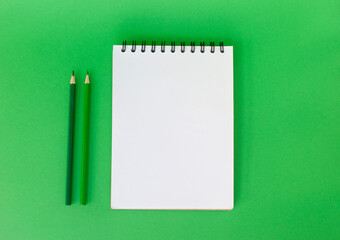 School supplies on bright green background with copyspace. Back to school concept.