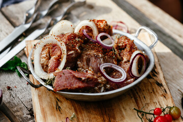 Marinated pork for shish kebab in an iron micron. Raw meat