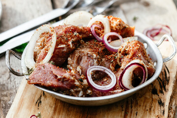 Marinated pork for shish kebab in an iron micron. Raw meat