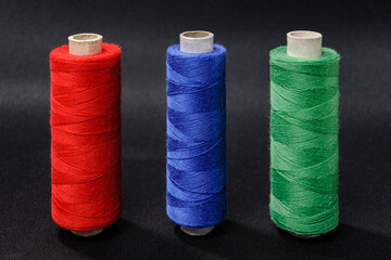 threads red blue green on black background