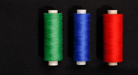 threads green blue red on black background