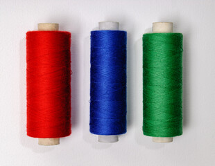 threads red blue green on white background