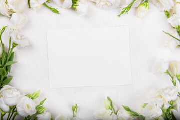 Obraz na płótnie Canvas Horizontal empty 7x5 card mockup with blooming white eustoma lisianthus flowers, design element for wedding invitation, thank you or greeting card. Spring background