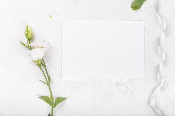 Horizontal empty 7x5 card mockup with blooming white eustoma lisianthus flowers, design element for wedding invitation, thank you or greeting card. Spring background