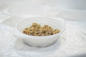 Food for the homeless. Plate with buckwheat on the table. Hot meal for lunch.
