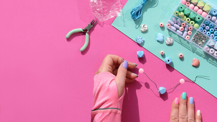 Handmade jewelry. Box with beads, hands with tools. Making handmade jewelry for yourself or as self...