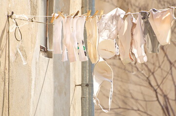White underwear and socks dry on the cord in the sun.