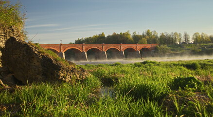 Long brick bridge in sunny spring morning, Kuldiga, Latvia. 