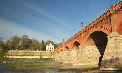 Long brick bridge in sunny spring morning, Kuldiga, Latvia. 