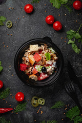 Delicious salad with chicken, olives and fresh herbs, a fresh salad on the menu of a fast food restaurant on a dark stone table. Healthy option of fast food..