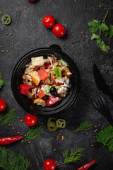 Delicious salad with chicken, olives and fresh herbs, a fresh salad on the menu of a fast food restaurant on a dark stone table. Healthy option of fast food..